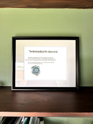 The Time Traveller & The Alarm Clock in a real frame, on the wall